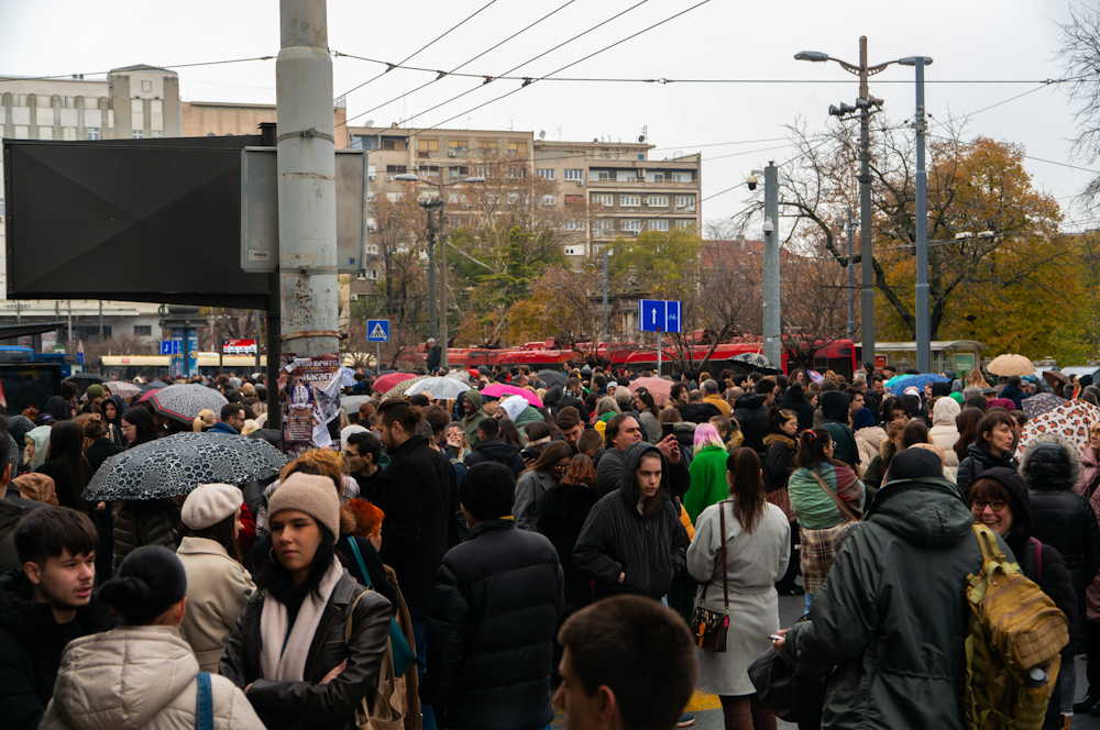 Massive crowd of protesters filling the street near the university rectorate on a rainy day in Belgrade